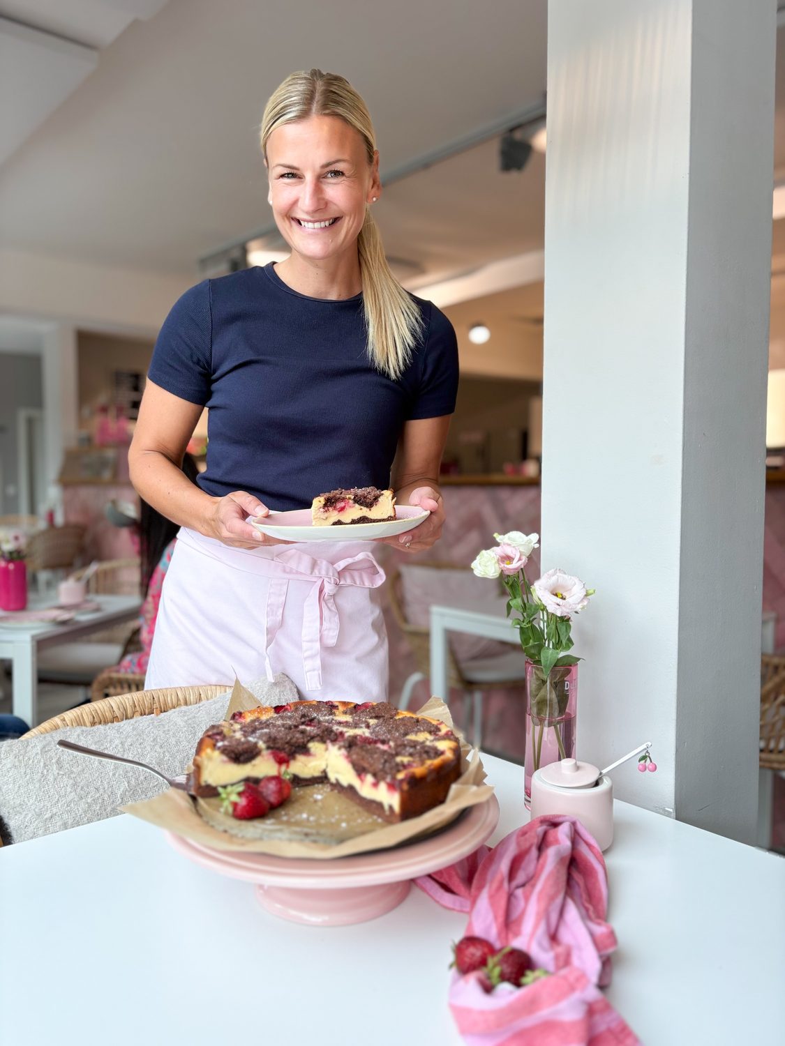 Julia Behncke mit einem Käsekuchen im Café Backgeflüster